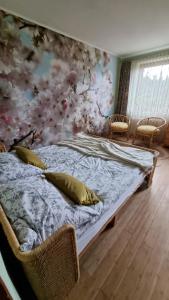 a bedroom with a bed with a floral wall at Agroturystyka u Bogusi in Sarbinowo