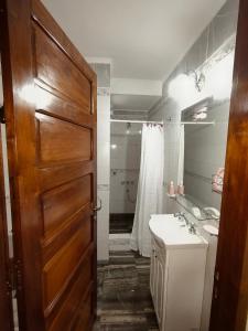 a bathroom with a wooden door and a sink at Refugio Quilmes Centro - Work & Relax in Quilmes +25 photos