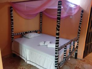 a bedroom with a bed with a canopy at Bububu creek house in Mombasa +6 photos