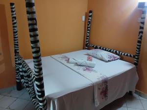 a bed with white sheets and pillows on it at Bububu creek house in Mombasa