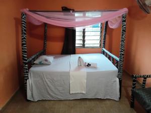 a bedroom with a bed with a canopy and a window at Bububu creek house in Mombasa