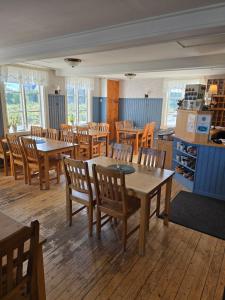 a dining room with wooden tables and wooden chairs at Turistgården Töcksfors in Töcksfors