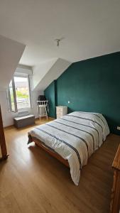 a bedroom with a large bed with a green wall at Résidence Le Soleil de Nousty in Nousty