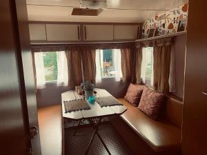 a small room with a table in a trailer at Venez Dormir chez Nous Dans Les BaRoNNieS ! Dans notre Caravane CARavelaiR 1979 in Labastide +64 photos