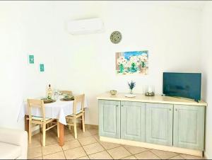 a dining room with a table and a tv on top at Casa Minuredda in Olbia