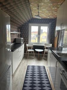 a kitchen with white cabinets and a table and a window at Faruqshus in Mönsterås