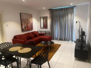 a living room with a red couch and a table at Embassy Gardens Studio Accra in Accra
