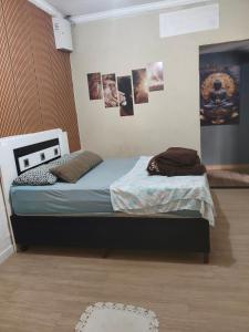 two beds in a room with pictures on the wall at Hostel Durães 01 in Londrina +8 photos