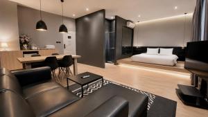 a living room with a couch and a bed at Srianunt Boutique Hotel in Buriram