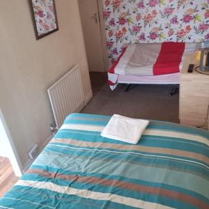 a bedroom with a bed with a colorful blanket at New Hawkes Hotel in Blackpool