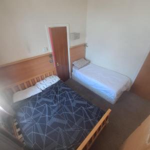 a small room with two beds in it at New Hawkes Hotel in Blackpool