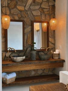 a stone bathroom with two sinks and a mirror at Kiterise Tatajuba in Tatajuba
