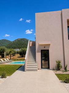 a house with a stairway leading to a door at Minimal Suites in Skala Rachoniou