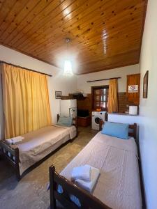 a bedroom with two beds and a wooden ceiling at XeniCamp & Bungalows in Tolo +48 photos