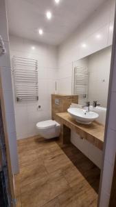 a bathroom with two sinks and a toilet in it at Agroturystyka u Bogusi in Sarbinowo