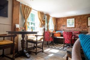 a dining room with chairs and a table and a brick wall at The Vineyard Lamberhurst in Lamberhurst