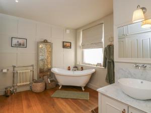 a bathroom with a large white tub and a sink at Cotswold House in Moreton in Marsh +64 photos