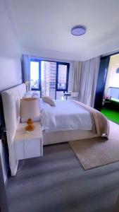a bedroom with a large white bed and a table at SS Kileleshwa Homes in Nairobi