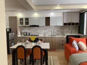 a kitchen and living room with a table and a couch at SS Kileleshwa Homes in Nairobi