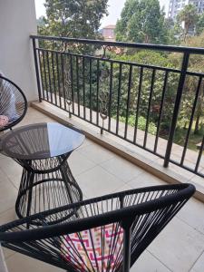 a balcony with a chair and an umbrella at SS Kileleshwa Homes in Nairobi