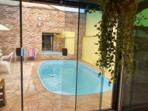a swimming pool in a house with a glass enclosure at Hostel Durães 01 in Londrina