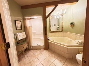 a bathroom with a tub and a toilet and a sink at The Barn Inn Bed and Breakfast in Millersburg +75 photos
