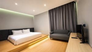 a bedroom with a bed and a chair and a television at Srianunt Boutique Hotel in Buriram +7 photos