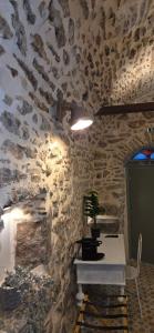 ein Raum mit einer Steinwand mit einem Tisch und einer Pflanze in der Unterkunft Parakathi Mesta in Mestá