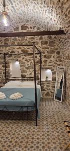 ein Schlafzimmer mit einem Bett in einer Steinwand in der Unterkunft Parakathi Mesta in Mestá