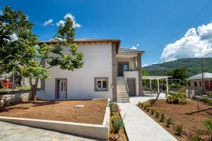 a white house with a garden in front of it at Zen Garden Villa in Theológos
