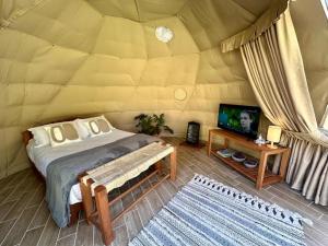 ein Schlafzimmer mit Bett und Fernseher in einer Jurte in der Unterkunft Lunada Mazamitla in Mazamitla