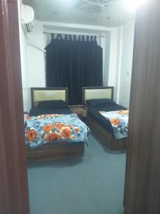 two beds in a room with a mirror at موتيل كاكه باران in Erbil