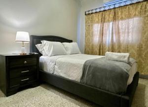 a bedroom with a bed with a dresser and a window at Exclusive Casa Oro 3VX in San Pedro Sula