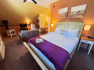 a bedroom with a large bed and a living room at The Barn Inn Bed and Breakfast in Millersburg
