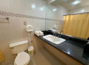 a bathroom with a toilet and a sink and a mirror at Exclusive Casa Oro 3VX in San Pedro Sula