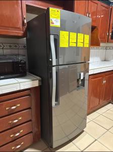 a refrigerator in a kitchen with signs on it at Exclusive Casa Oro 3VX in San Pedro Sula