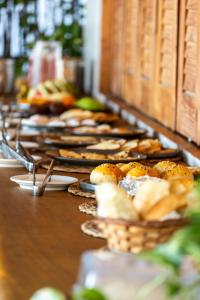 a buffet line with plates of food and baskets of bread at Kiterise Tatajuba in Tatajuba