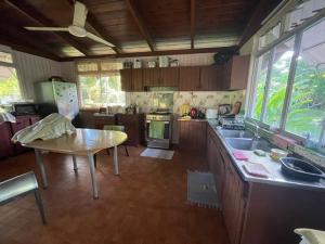 a large kitchen with a table and a table and a tableablish at Fare Taitua in Papara