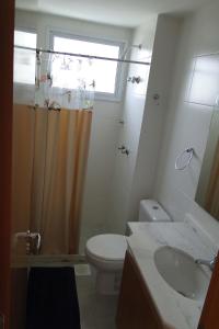 baño con aseo y lavabo y ventana en Apartamento Completo no Jardim da Barra - Barra Olímpica, en Río de Janeiro