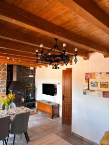 a dining room with a fireplace and a chandelier at Los Ayales in Huelamos
