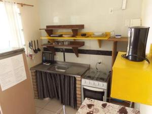 a small kitchen with a stove and a sink at Recanto Dos Vargas - Seu refúgio em Floripa com atendimento dos anfitriões in Florianópolis