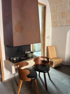 a kitchen with a table and two chairs and a stove at SUITES JACUZZI La Stratodda OSTUNI Torre Guaceto in San Vito dei Normanni