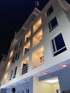 a large white building with lights on it at night at POSH HOTEL iSLAND in Victoria Island