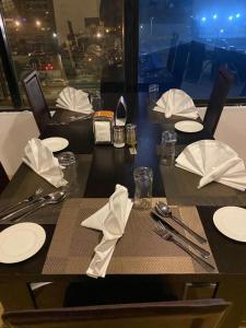 a black table with white plates and napkins on it at POSH HOTEL iSLAND in Victoria Island