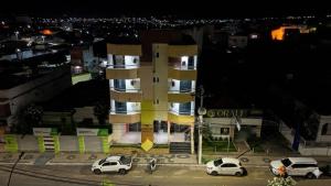 a building with cars parked in a parking lot at Araújo Hotel in Itaberaba