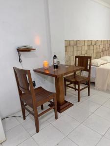 a wooden table and chairs in a room with a bed at Araújo Hotel in Itaberaba