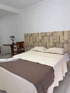 a bedroom with a large bed and a table at Araújo Hotel in Itaberaba