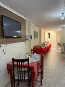 a room with three tables with red table cloths and a flat screen tv at Araújo Hotel in Itaberaba +4 photos