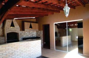 a kitchen with a brick fireplace and a glass door at Hostel Durães 01 in Londrina