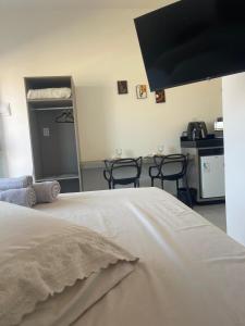 a bedroom with a bed and two tables and chairs at Alphaville Studios in Pirapora